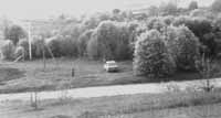 Vishnive Jewish cemetery with vehicles parked on former cemetery land, May 1996